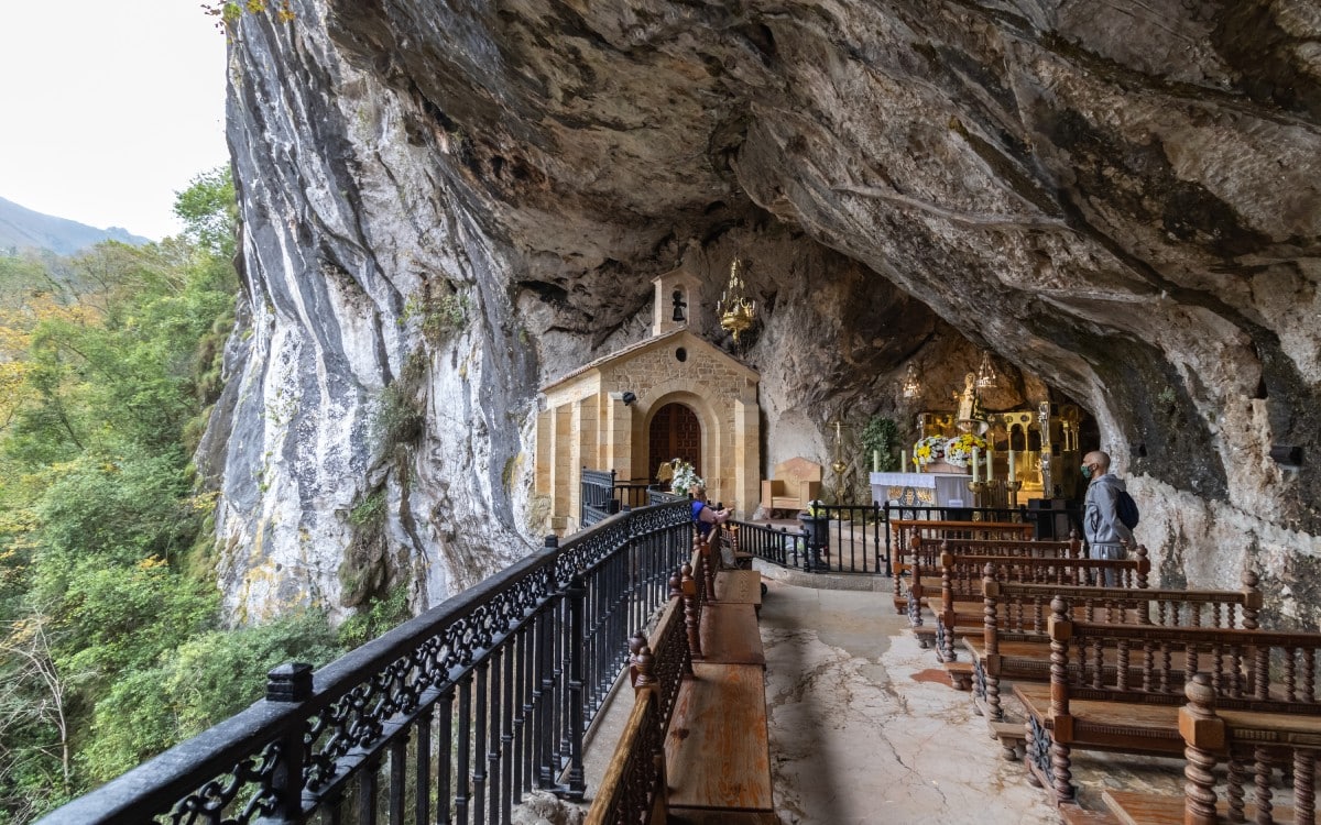 The Santina in the Holy Cave of Covadonga, located in a natural niche above a waterfall in the heart of the Asturias mountains.