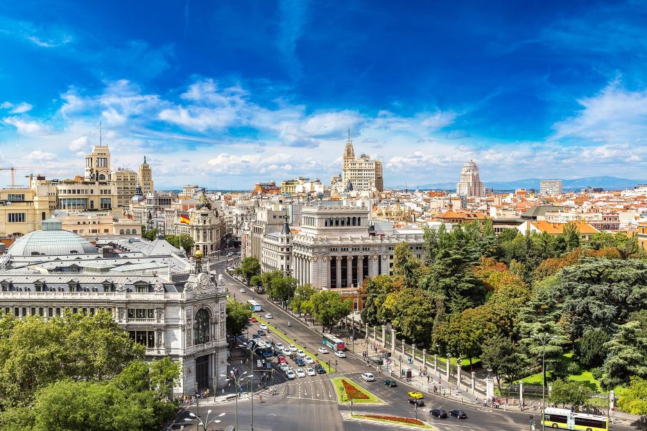Madrid from above: a sea of reddish rooftops and majestic domes telling the history of Spain's capital under the golden light of the plateau.